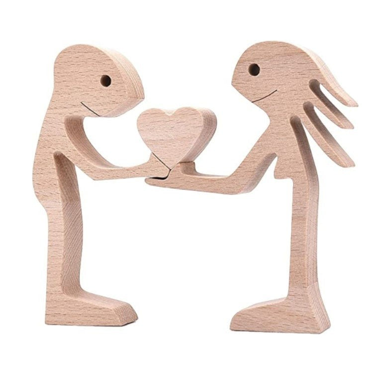 Sculpture en bois de deux personnages stylisés s'offrant un cœur, décoration artisanale, bois naturel.