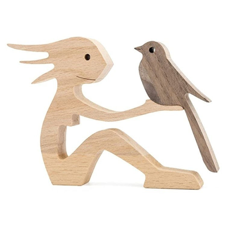 Sculpture en bois d'une figure humaine assise tenant un oiseau sur son bras, décoration artisanale.